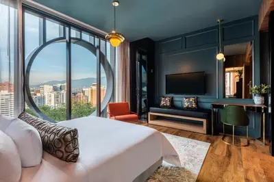 a bedroom with a large bed and a large window at Hotel Marquee Medellín in Medellín