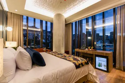 a bedroom with a bed and a large window at Hotel Marquee Medellín in Medellín