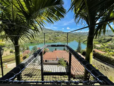 a swinging cage with a view of a river at Glamping Montecarlo Domo Geodesico y Sauna Finlandés Guatapé in Guatapé