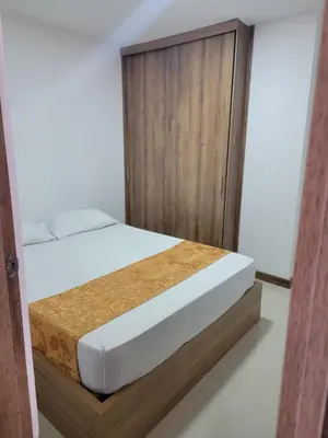 a bedroom with a bed with a wooden cabinet at Apartamento FL Martinz in Manizales