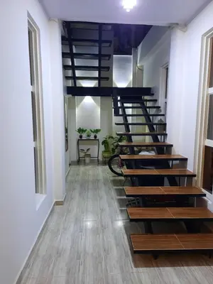 a spiral staircase in a room with white walls and wooden floors at Como en casa in La Dorada