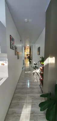 a hallway with white walls and a long hallway with chairs at Como en casa in La Dorada