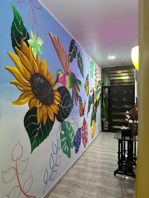 a hallway with a mural of a sunflower and birds at Como en casa in La Dorada