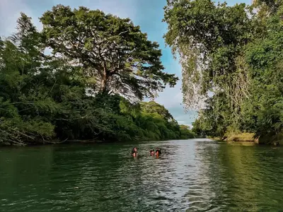 two people in the water in a river at Refugio Monte Oscuro in Las Mercedes