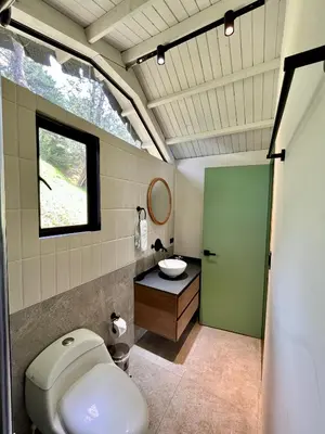 a bathroom with a toilet and a sink and a window at Soy Local Guatape Campestre in Guatapé