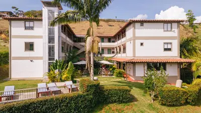 an exterior view of a building with chairs and trees at Soy Local Guatape Campestre in Guatapé