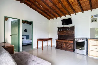 a living room with a couch and a tv on the wall at Soy Local Guatape Campestre in Guatapé