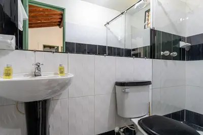 a bathroom with a sink and a toilet and a mirror at Soy Local Guatape Campestre in Guatapé