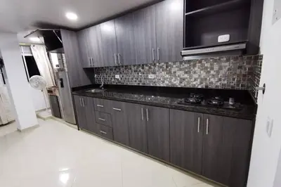 a kitchen with dark wood cabinets and a microwave at Hermoso y cómodo apartamento in San Rafael