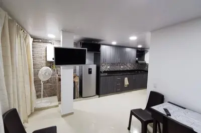 a kitchen with a tv and a table and chairs at Hermoso y cómodo apartamento in San Rafael