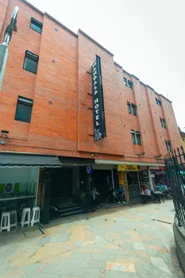 a large red brick building with a sign on it at Mandala Medellin Botero By GyC Hotels in Medellín