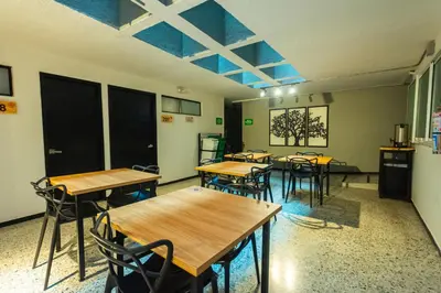 a classroom with tables and chairs in a room at Mandala Medellin Botero By GyC Hotels in Medellín