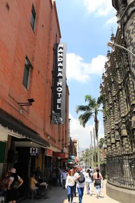 a group of people walking down a city street at Mandala Medellin Botero By GyC Hotels in Medellín
