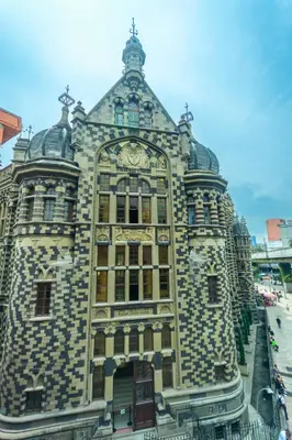 a large stone building with a clock on it at Mandala Medellin Botero By GyC Hotels in Medellín