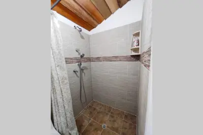 a shower stall in a bathroom with a tiled floor at Finca La Antigua. finca tradicional Cafetera in Jardin