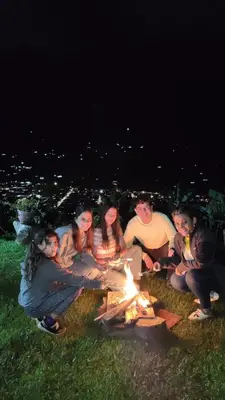 a group of people sitting around a fire at Finca La Antigua. finca tradicional Cafetera in Jardin