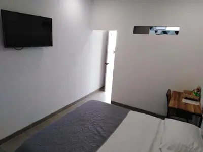 a bedroom with a bed and a flat screen tv at Hotel HACIENDA SAN AGUSTIN in Marinilla
