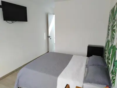 a bedroom with a bed and a flat screen tv at Hotel HACIENDA SAN AGUSTIN in Marinilla