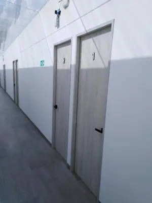 a row of doors in a hallway in a building at Hotel HACIENDA SAN AGUSTIN in Marinilla
