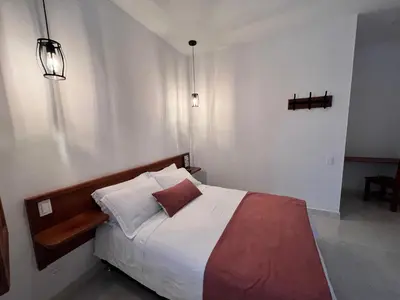 a bedroom with a bed with white and red sheets at Casa Isabel Hotel in Jardin