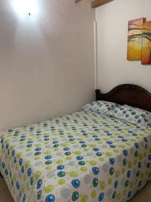 a bed with a polka dot blanket on it at Apartamento La Esperanza Guatapé in Guatapé