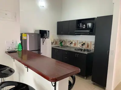 a kitchen with black cabinets and a wooden table at Apartamento La Esperanza Guatapé in Guatapé