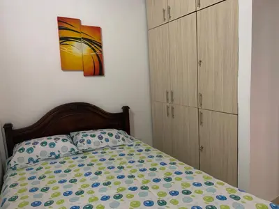a bedroom with a bed and a painting on the wall at Apartamento La Esperanza Guatapé in Guatapé