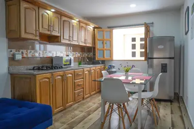 a kitchen with wooden cabinets and a table with chairs at Roble Colonial - Apartamentos Deluxe en Guatapé in Guatapé
