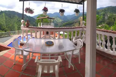 a patio with a table and chairs on a balcony at Apartamento campestre in Manizales