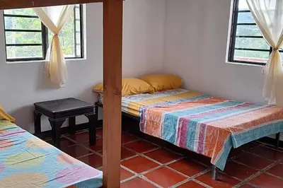 a room with two beds and a table and windows at Apartamento campestre in Manizales