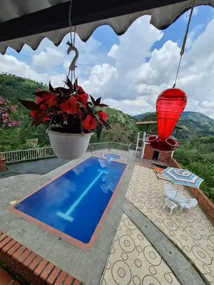 a villa with a pool and a view of the mountains at Apartamento campestre in Manizales
