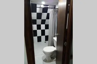 a bathroom with a black and white checkered wall at YoamoJardin ... es como estar en casa in Jardin