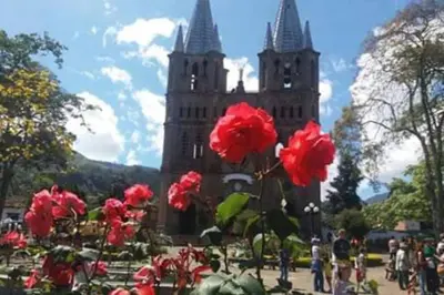 a group of red flowers in front of a building at YoamoJardin ... es como estar en casa in Jardin