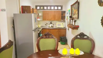 a kitchen with a table and chairs and a refrigerator at YoamoJardin ... es como estar en casa in Jardin