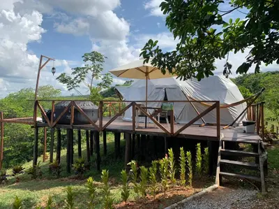 a wooden deck with two tents and an umbrella at Eco-Glamping Shalom in Mariquita