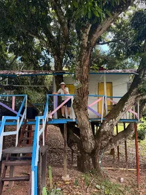 a man sitting on a porch of a tree house at Eco-Glamping Shalom in Mariquita