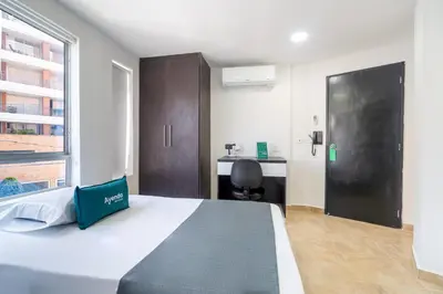 a bedroom with a large bed and a desk at Ayenda Coliving la 78A in Medellín