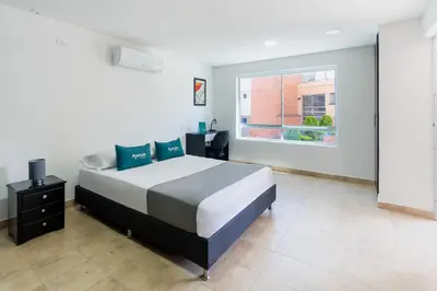 a bedroom with a large bed and a window at Ayenda Coliving la 78A in Medellín