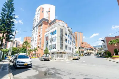a building on the side of a street with cars at Ayenda Coliving la 78A in Medellín