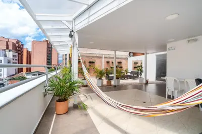 a hammock on a balcony with a view of a city at Ayenda Coliving la 78A in Medellín