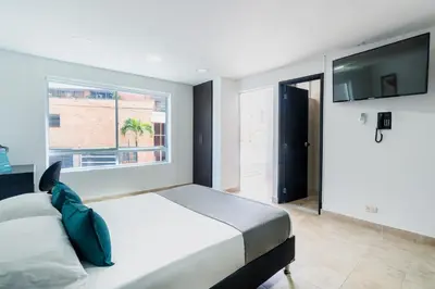 a bedroom with a large bed and a window at Ayenda Coliving la 78A in Medellín