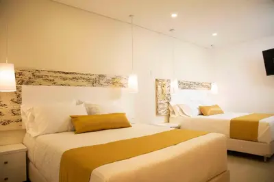 a hotel room with two beds and a tv at Hotel Silver Guarne in Guarne