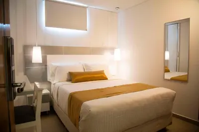 a bedroom with a large bed and a mirror at Hotel Silver Guarne in Guarne