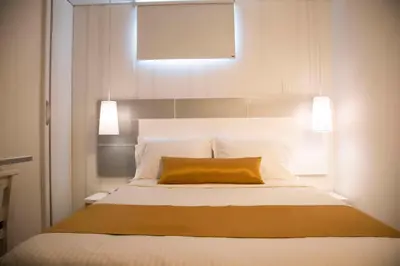 a bedroom with a bed with a yellow pillow on it at Hotel Silver Guarne in Guarne