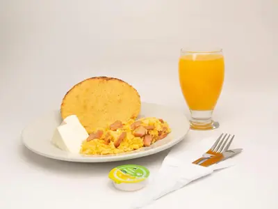 a plate of breakfast food with toast and a glass of orange juice at Hotel Silver Guarne in Guarne