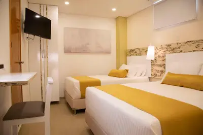 a hotel room with two beds and a flat screen tv at Hotel Silver Guarne in Guarne
