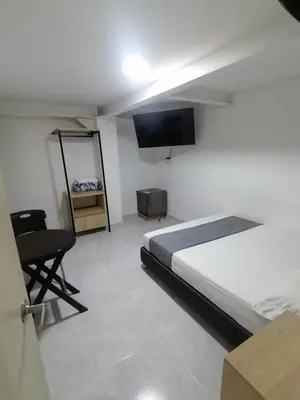 a bedroom with a bed and a flat screen tv at Hotel Urbano 70 in Medellín