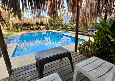 a pool with a bench and a stool next to it at Finca Hotel Tierra Verde in Girardota