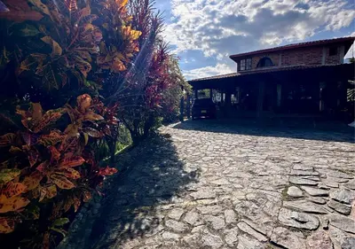 a stone walkway next to a house with a building at Finca Hotel Tierra Verde in Girardota