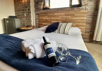 a bottle of wine and a glass on a bed at Finca Hotel Tierra Verde in Girardota